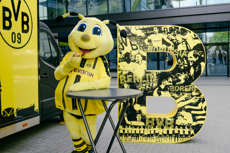 Borussia Dortmund BVB Pokalfinale 2016 Maskottchen EMMA isst eine Bratwurst für Reise nach Berlin